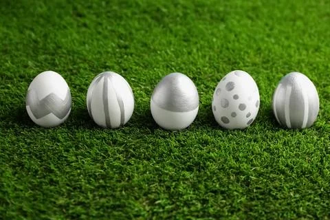 Line of painted Easter eggs on green lawn Stock Photos