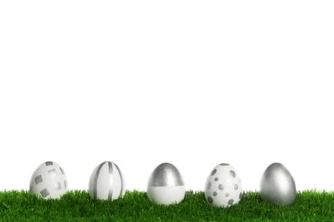 Line of painted Easter eggs on green lawn against white background Stock Photos