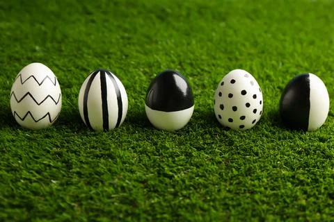 Line of painted Easter eggs on green lawn Stock Photos