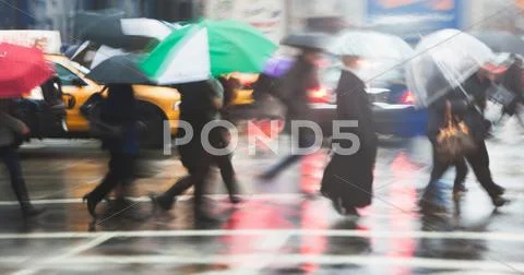 Line Of People Crossing City Street In Rain