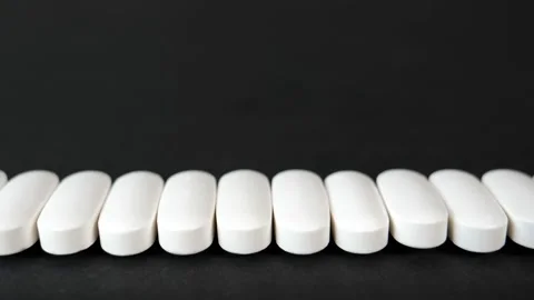 Line of pills moving sideways on black background Vídeo Stock 201469607