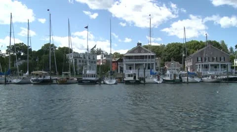 A line of sail boats moored in front of homes. Stock Footage 8980915