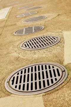 Line up of sewer drains Stock Photos