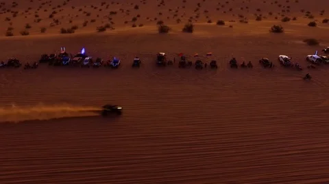 Line of vehicles watch two dune buggies race Stock Footage 99158542