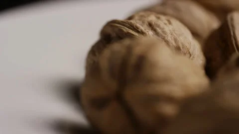 Line of whole walnuts in shells on white surface Stock Footage 328143670