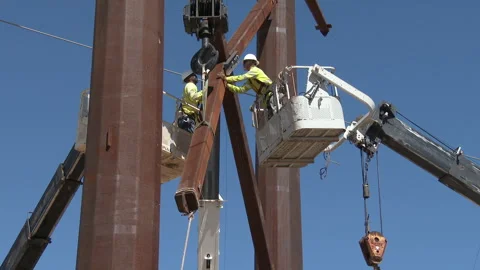 Line workers secure a brace between two giant steel power poles, 4K. Stock Footage 244489838