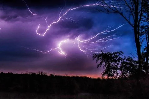 Linear lightning in a purple sky at the night Stock Photos