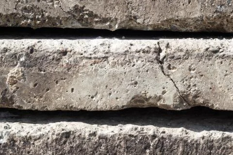 Linear texture of gray concrete slabs with a crack stacked on top of each oth Stock Photos