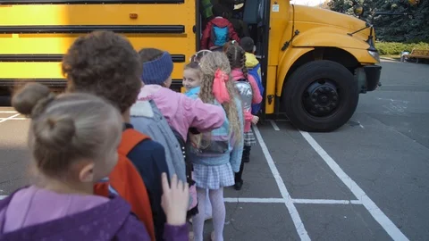 Lined up elementary age kids boarding school bus Stock Footage 122263004