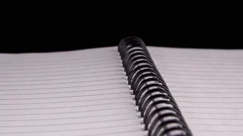Lined empty notepad close up isolated against black background stock footage Stock Footage 220460750