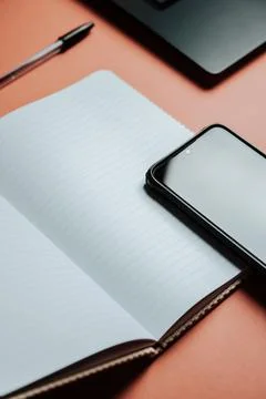 Lined notebook with a cellphone resting on Background Wallpaper Stock Photos