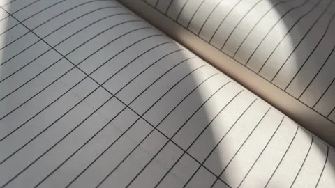 Lined Notebook Pages Flipping with Sunlight and Shadow Overlays Stock Footage 340214846