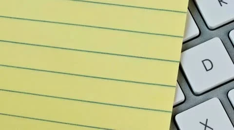 Lined pad of paper and a computer keyboard Stock Footage 20544365