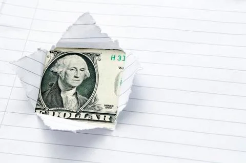 Lined paper torn with window opening showing US dollar Stock Photos