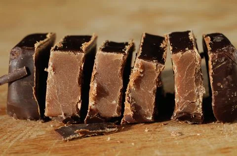 Lined up pieces of chocolate candy closeup. Shallow depth of field Stock Photos