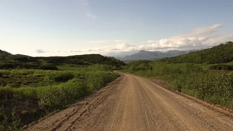Lined sandy road between the hills and mountains Stock Footage 72856826