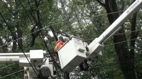 Lineman arrives in bouncing bucket, helps other lineman, working in rain Stock-Footage 8847748