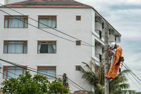Lineman Climbing Concrete Utility Pole to Repair Overhead Electrical Wiring Stock-Fotos