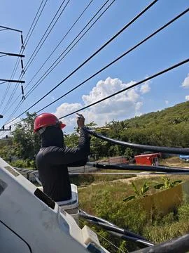 Lineman technician working on high voltage aerial bundle cable. Stock Photos