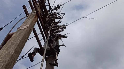 A lineman while working on an electricity pole on a hot sunny day Stock Footage 139103932