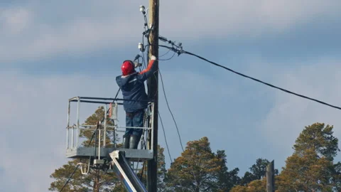 Lineman working on electrical pole using a lift platform Stockbeeldmateriaal 304499531