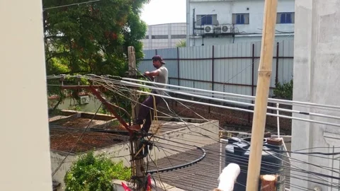 Lineman working on street pole for new house current connection at suraram Stock Footage 345523383