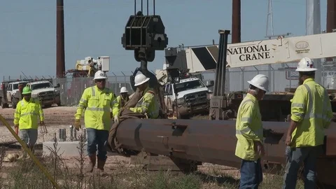 Linemen attach hook to metal pole as they prepare to lift it, 4K. Stock Footage 80929631