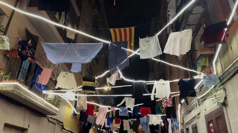 Linen clothes hang on lines between houses in an old district of Barcelona. Stock Footage 303505662
