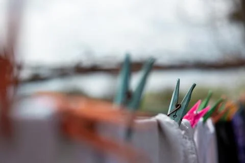 Linen dries on a rope, attached with multi-colored clothespins Stock Photos