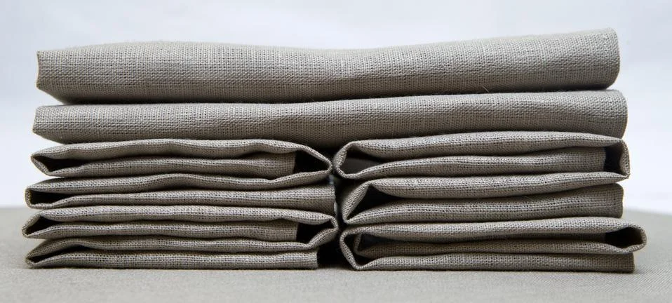Linen napkins gray folded creatively. Stock Photos