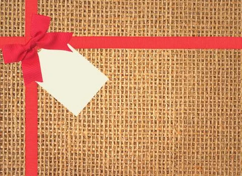 Linen texture background with red ribbon, bow and tag Fotos de archivo