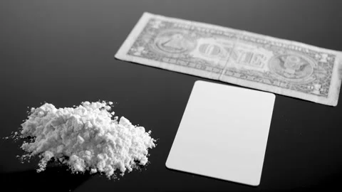 Lines of cocaine and a dollar bill. Cocaine lines shots on a black table glass. Vídeo Stock 150556507