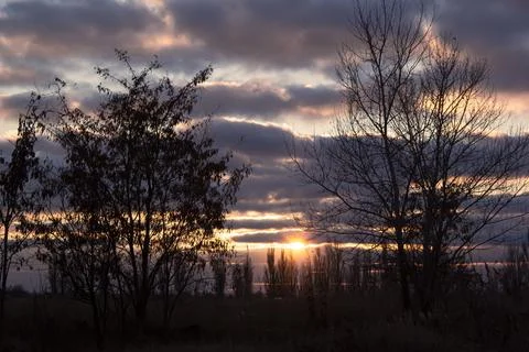 Lines of dramatic clouds at sunset with reflection in the river Stock Photos