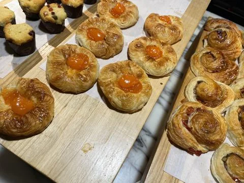 Lines of fresh baked sweet puff pastry stuffed with apricot and peach jelly Stock Photos