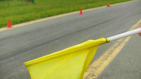 Linesman makes three swing with a yellow flag. Two cars drive one after another Stock Footage 129920706