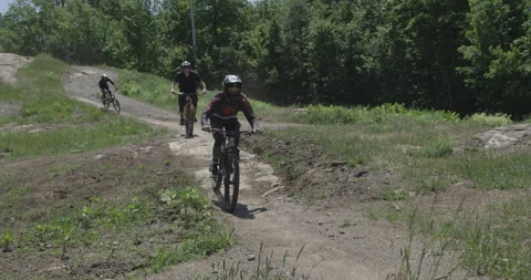 Lineup of riders racing down the trail on mountain bikes Stock Footage 157325569