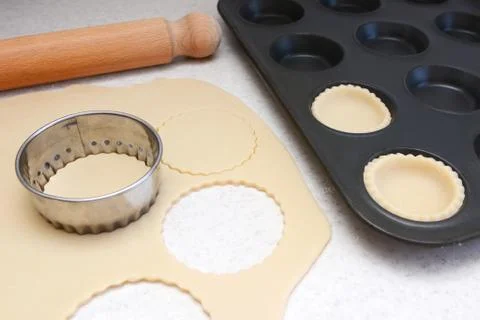 Lining a bun tin with circles of rolled out pastry Stock Photos