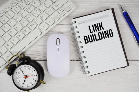 Link Building text with alarm clock, keyboard and wireless mouse on wooden .. Stock Photos