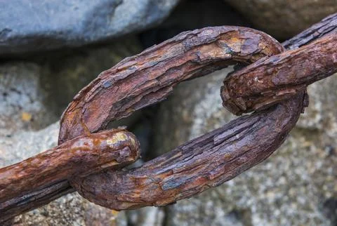 Link of a rusty and strong chain on rocks, Mousehole, Verenigd Koninkrijk Stock Photos