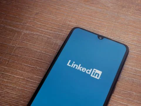 LinkedIn app launch screen on smartphone on wooden background Stock Photos