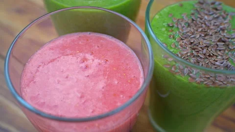 Linseeds falling down into glass with smoothie, preparing healthy cocktail Stock Footage 137968357