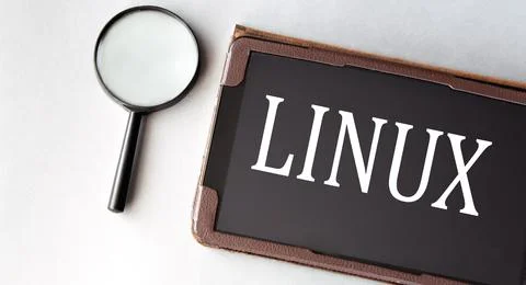 LINUX - word in electronic notebook on white background with magnifying glass Фото