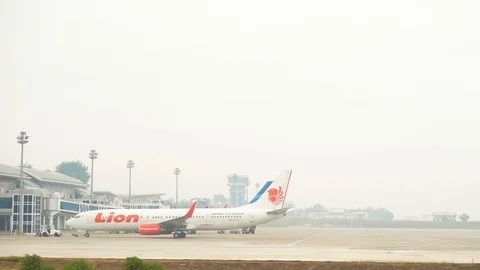 Lion Air Airlines back off besides Garuda Indonesia Plane at Airport Jambi. Stock Footage 116651975