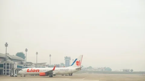 Lion Air Airlines back off besides Garuda Indonesia plane at airport Stock Footage 116652166