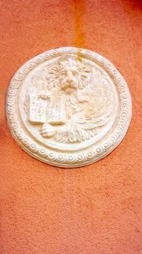 Lion in circular shape bas relief art on orangel wall Stock Photos