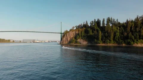 Lions Gate Bridge in Vancouver's harbor with pleasure craft passing by next to Stock Footage 140948091