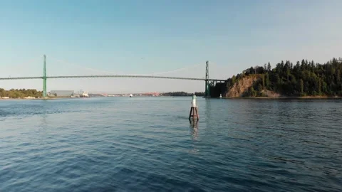 Lions Gate Bridge in Vancouver's harbor with pleasure craft passing by next to Stock Footage 140948397
