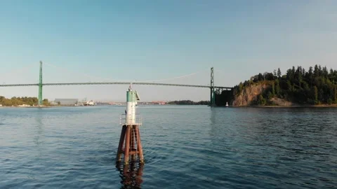Lions Gate Bridge in Vancouver's harbor with pleasure craft passing by next to Stock Footage 144409489