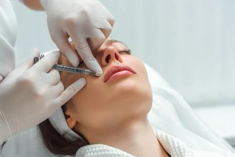 Lip augmentation and correction procedure in a cosmetology salon. The specialist Stock Photos