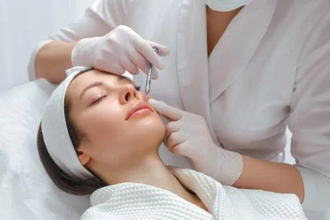 Lip augmentation and correction procedure in a cosmetology salon. The specialist Stock Photos